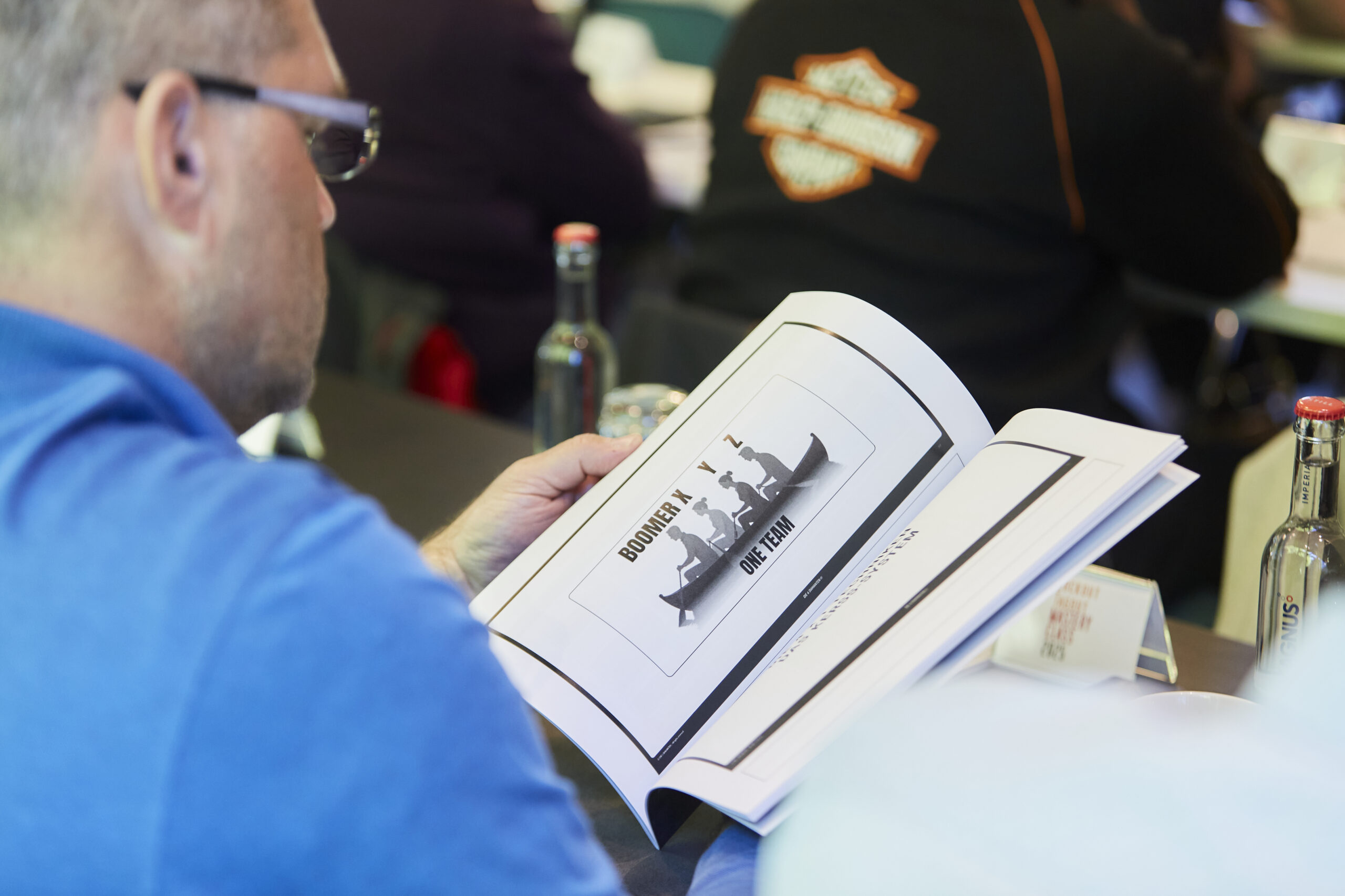 Teilnehmer der Lockout/Tagout Mastery Class betrachten ein Schulungsdokument mit technischen Illustrationen während des Seminars.